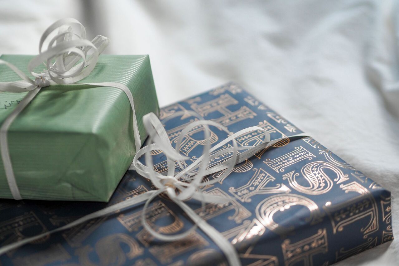 Gifts wrapped in sage and navy paper with silver ribbon